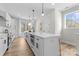 Spacious kitchen showcasing pendant lighting, white cabinets, quartz countertops, and stainless appliances at 3220 Riley Ave, Charlotte, NC 28269