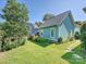 View of the backyard with a lush green lawn, flowerbeds, and a stone walkway at 332 Delburg St, Davidson, NC 28036