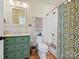 Charming bathroom with a vanity featuring a green painted cabinet, tiled shower, and decorative fixtures at 332 Delburg St, Davidson, NC 28036
