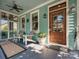 Inviting front porch featuring a wooden door, colorful chairs, and tranquil decor at 332 Delburg St, Davidson, NC 28036