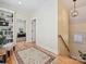 Bright hallway with hardwood floors, stylish rug, staircase, and built-in bookcase near an entry with view to the office at 332 Delburg St, Davidson, NC 28036