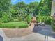 Expansive backyard featuring an outdoor fireplace, lounge area, mature trees, and green lawn at 3620 Champaign St, Charlotte, NC 28210