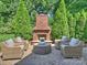 Brick outdoor fireplace with lounge area and lush greenery in a well-maintained backyard at 3620 Champaign St, Charlotte, NC 28210