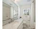Bright bathroom with a walk-in shower, marble countertop, and tiled flooring at 3620 Champaign St, Charlotte, NC 28210