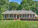 Charming brick home featuring manicured lawn, mature trees, and neatly trimmed shrubs at 3620 Champaign St, Charlotte, NC 28210