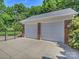 Two-car garage featuring brick accents, carriage style doors, and an attached driveway at 3620 Champaign St, Charlotte, NC 28210