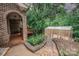 Charming brick home with an enclosed porch, manicured garden, and greenhouse beyond at 3700 Nw Gainesway Nw Ct, Concord, NC 28027