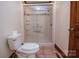 Bathroom with shower and toilet, featuring tile floors and shower with grab bars at 3700 Nw Gainesway Nw Ct, Concord, NC 28027