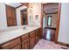 Bright bathroom featuring a vanity with lots of cabinet space, a large mirror, and a doorway leading to an adjacent room at 3700 Nw Gainesway Nw Ct, Concord, NC 28027