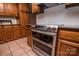 Kitchen area featuring stainless steel appliances, wooden cabinets, tile flooring, and modern fixtures at 3700 Nw Gainesway Nw Ct, Concord, NC 28027