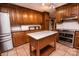 The kitchen boasts stainless steel appliances, wooden cabinets, tile flooring, and a kitchen island with a white countertop at 3700 Nw Gainesway Nw Ct, Concord, NC 28027