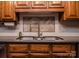 Close up shot of a stainless steel kitchen sink featuring wooden cabinets, stainless steel faucet, and tile backsplash at 3700 Nw Gainesway Nw Ct, Concord, NC 28027