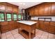 A large kitchen featuring wooden cabinets, white backsplash, stainless steel appliances, and a kitchen island with a white countertop at 3700 Nw Gainesway Nw Ct, Concord, NC 28027