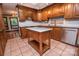 A kitchen featuring wooden cabinets, white backsplash, stainless steel appliances, and a kitchen island with a white countertop at 3700 Nw Gainesway Nw Ct, Concord, NC 28027