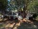 Home featuring a screened porch in a tranquil wooded setting, offering a serene and private outdoor space at 400 Archibald Rd, Concord, NC 28025
