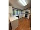 Well-lit kitchen featuring white cabinets, stainless steel appliances, and wood flooring at 400 Archibald Rd, Concord, NC 28025
