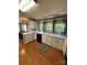 Well-lit kitchen featuring white cabinets, stainless steel appliances, and wood flooring at 400 Archibald Rd, Concord, NC 28025