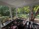 Screened-in porch with wooden floor, offering a peaceful view of the backyard's lush greenery at 400 Archibald Rd, Concord, NC 28025