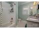 Bright bathroom with a double sink, white tiled shower and tub, and a classic black and white tiled floor at 417 N Dotger Ave, Charlotte, NC 28204