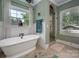 Bright bathroom features a soaking tub, walk-in shower, and large windows at 417 N Dotger Ave, Charlotte, NC 28204