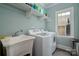Efficient laundry room featuring modern washer and dryer units, sink, and storage shelf at 417 N Dotger Ave, Charlotte, NC 28204