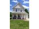 Charming two-story home with a covered front porch, hanging chairs, and beautiful landscaping at 417 Trillium Sw Ct, Conover, NC 28613