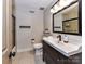 A bright bathroom features a glass shower and a dark vanity at 4711 Truscott Rd, Charlotte, NC 28226