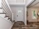 Bright entryway with decorative wood floors, staircase, and stylish front door at 4711 Truscott Rd, Charlotte, NC 28226