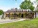 Charming single-story home featuring a welcoming front porch, dormer windows, and lush landscaping at 4711 Truscott Rd, Charlotte, NC 28226