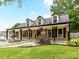 Inviting single-story home with a covered front porch, dormer windows, and a well-manicured lawn at 4711 Truscott Rd, Charlotte, NC 28226