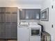 Laundry room with gray cabinets, updated washer and dryer, and ample storage at 4711 Truscott Rd, Charlotte, NC 28226