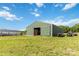 Large green barn with open doors on a lush, expansive property with equipment outside at 4855 Saluda Rd, Rock Hill, SC 29730