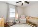 Bedroom features a cozy chair, crib, and changing table, illuminated by natural light at 4855 Saluda Rd, Rock Hill, SC 29730