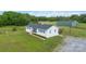 Charming white home with a dark roof, surrounded by green lawns and a matching barn in the background at 4855 Saluda Rd, Rock Hill, SC 29730