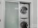 Laundry room features stacked washer and dryer with sliding glass doors at 513 N Graham St # 1B, Charlotte, NC 28202