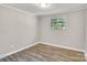 Neutral bedroom featuring new flooring, light walls, and a large window at 5221 Wales St, Charlotte, NC 28269