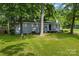 Beautiful single-story brick home with a well-manicured lawn, mature trees, and a welcoming front entrance with steps at 5221 Wales St, Charlotte, NC 28269