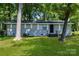 Charming single-story home with a gray painted brick exterior, well-maintained lawn, and mature trees at 5221 Wales St, Charlotte, NC 28269
