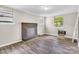 Living room featuring new flooring, a brick fireplace, and plenty of natural light from the windows at 5221 Wales St, Charlotte, NC 28269