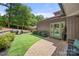 Beautiful backyard features a manicured lawn, brick pathway, lush landscaping, and an outdoor grill at 54 Honeysuckle Woods, Clover, SC 29710