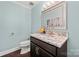 Stylish powder room featuring granite vanity top, decorative mirror, dark wood cabinet and hardwood flooring at 54 Honeysuckle Woods, Clover, SC 29710