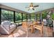 Bright sunroom with wood dining set, wicker chair, and large windows overlooking lush greenery and golf course at 54 Honeysuckle Woods, Clover, SC 29710