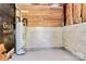Unfinished basement area with hot water heater, wood paneling, and cement flooring at 6517 Paleface Pl, Charlotte, NC 28214