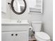 Bright bathroom featuring a stylish round mirror and clean white fixtures at 6517 Paleface Pl, Charlotte, NC 28214