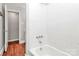 This bathroom features new tile, and a tub with modern fixtures at 6517 Paleface Pl, Charlotte, NC 28214