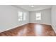 This bright bedroom features newly installed wood flooring, neutral paint, and multiple windows at 6517 Paleface Pl, Charlotte, NC 28214