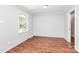 An empty bedroom with gleaming wood floors, a bright window, and freshly painted walls at 6517 Paleface Pl, Charlotte, NC 28214