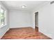 Newly renovated bedroom with a view into the hall featuring neutral paint and new wood flooring at 6517 Paleface Pl, Charlotte, NC 28214