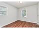 This is a bedroom with neutral walls, wood flooring, and window with blinds at 6517 Paleface Pl, Charlotte, NC 28214