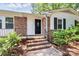Close-up of the front door with brick steps, manicured bushes and classic design elements at 6517 Paleface Pl, Charlotte, NC 28214